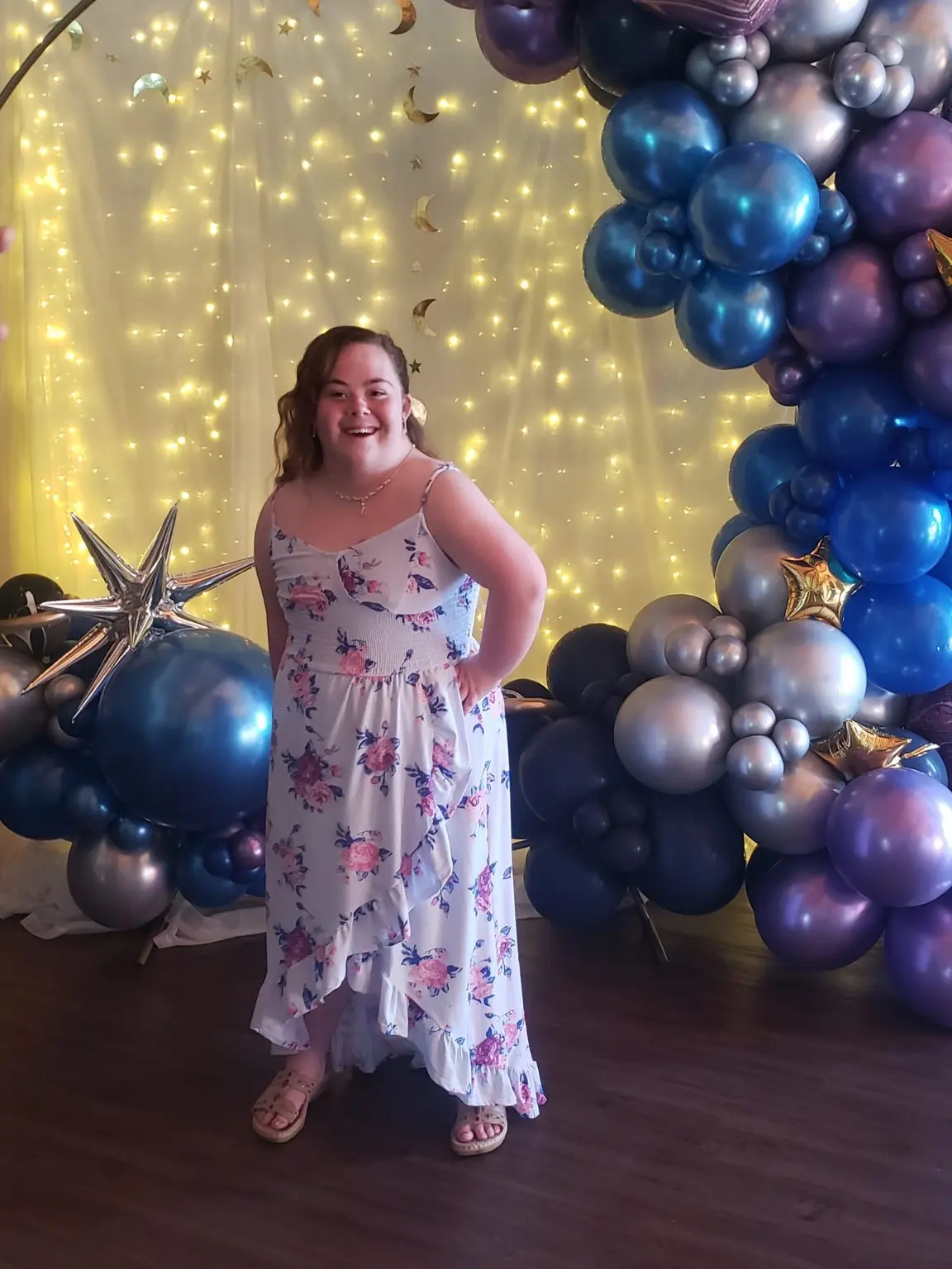 Lilah smiling at a celebration in a floral dress